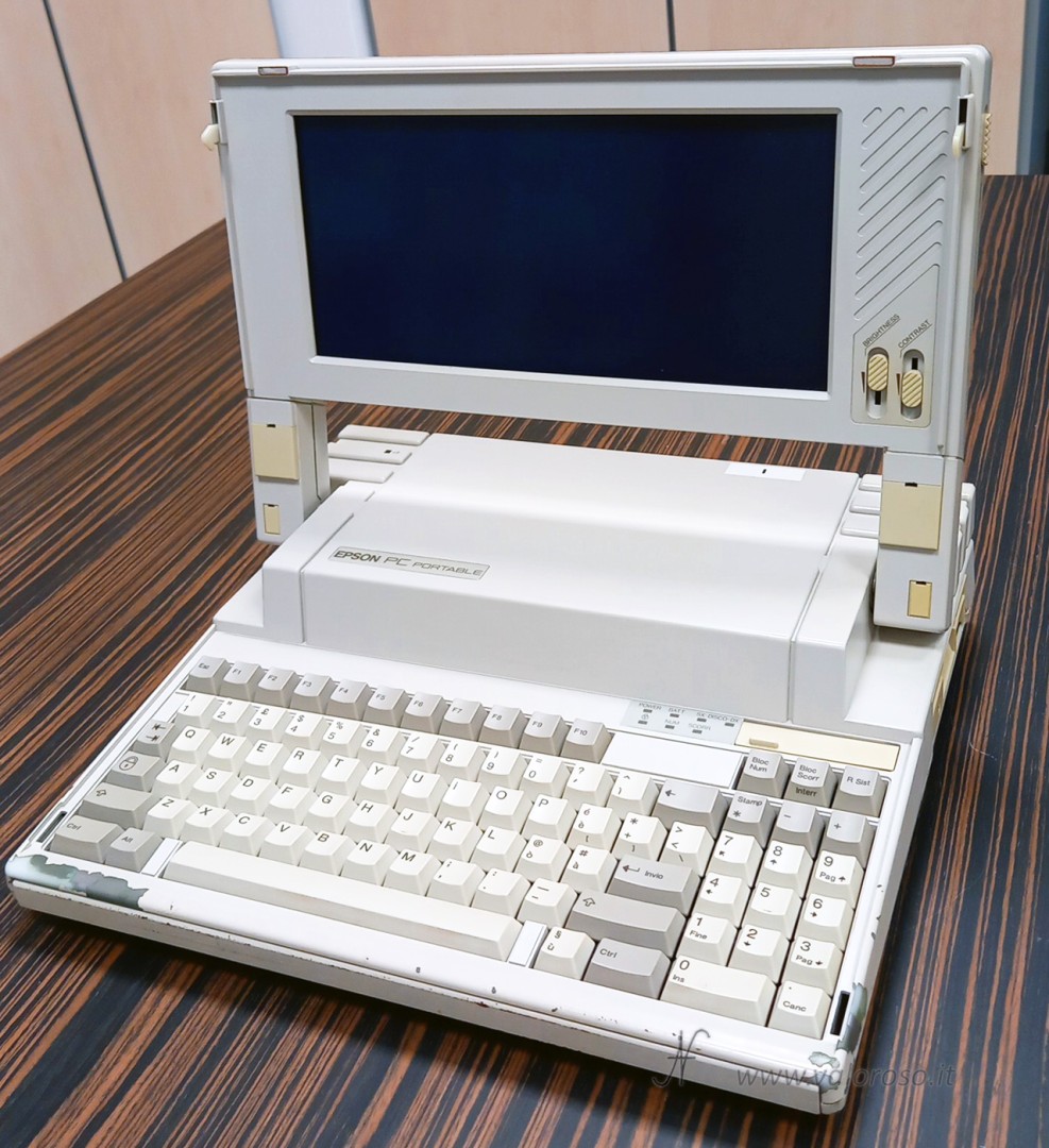 Epson Q150A, fine anni ’80, Intel 8088, 600 KB RAM. Alimentazione: 15 V, positivo centrale, fornita con alimentatore cinese regolabile. Errore 161 (batteria interna scarica), ma il computer, dopo un po’, parte. Avvia MS-DOS.