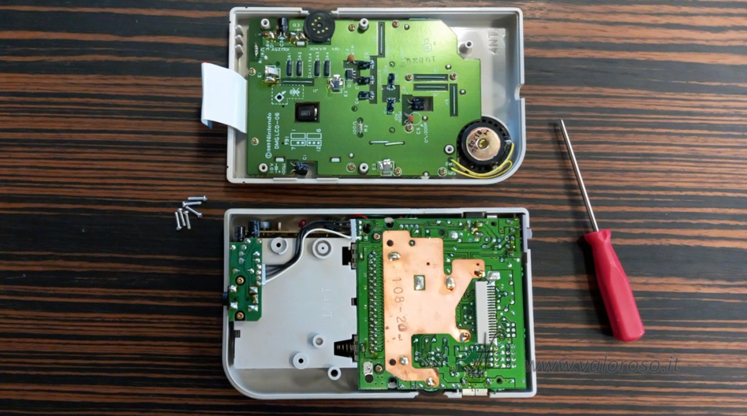 Separate front and rear shells, flat cable removed and tri-point screws grouped together. Neat preparation of the workbench for the repair of Game Boy vertical lines.