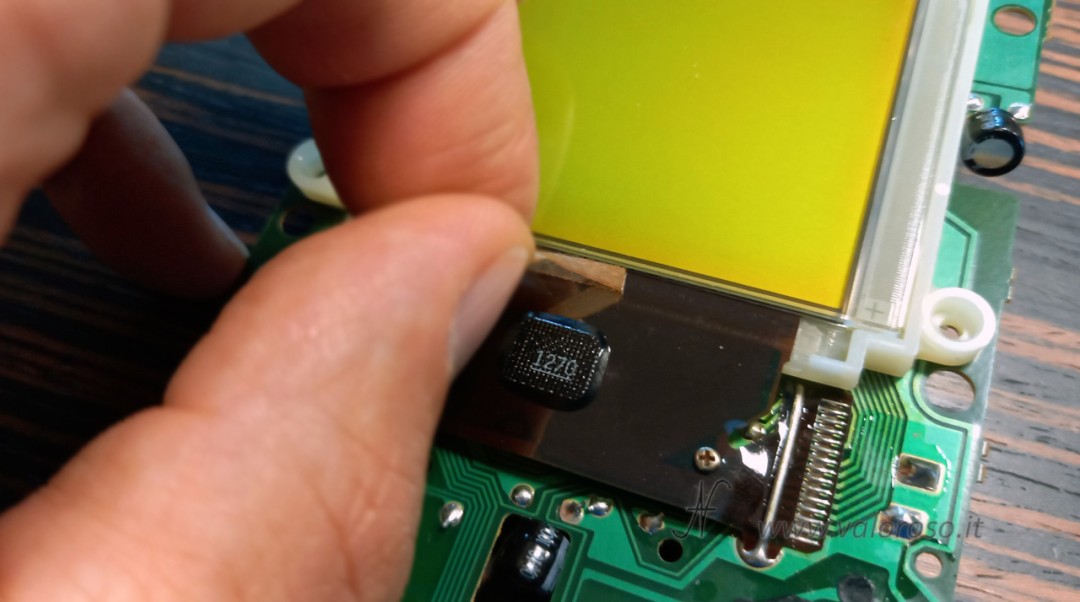 Removing the double-sided tape that fixed the spacer on the flat LCD. Preparing the screen edge for vertical line repair.