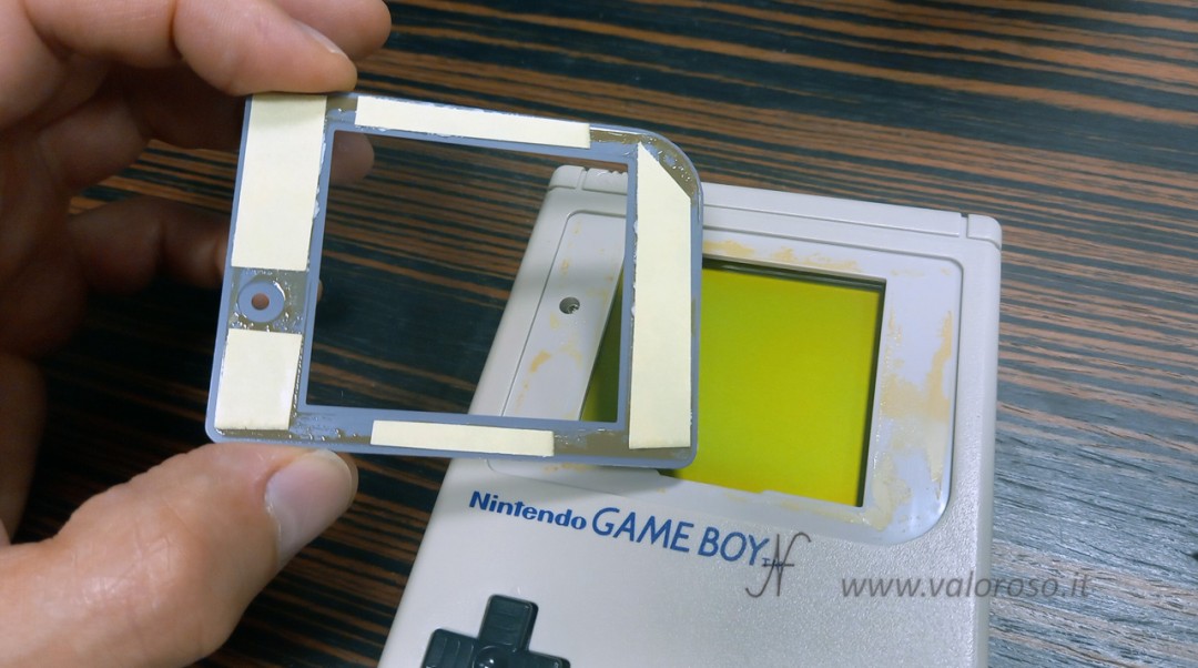 Gluing the mask with double-sided tape on the case, can also be done with the console closed. Final aesthetic finishing of the restoration and repair of the GameBoy Classic DMG-01 Game Boy.