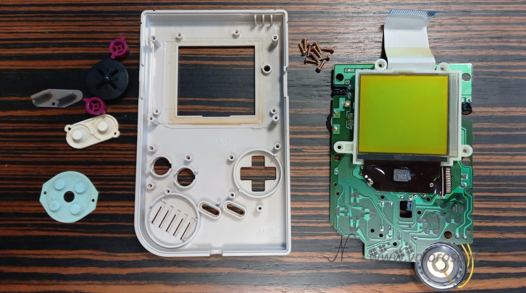 Raised display board and buttons with conductive membranes. Game Boy speaker. Disassembly phase preceding the repair of GameBoy monitor vertical lines.